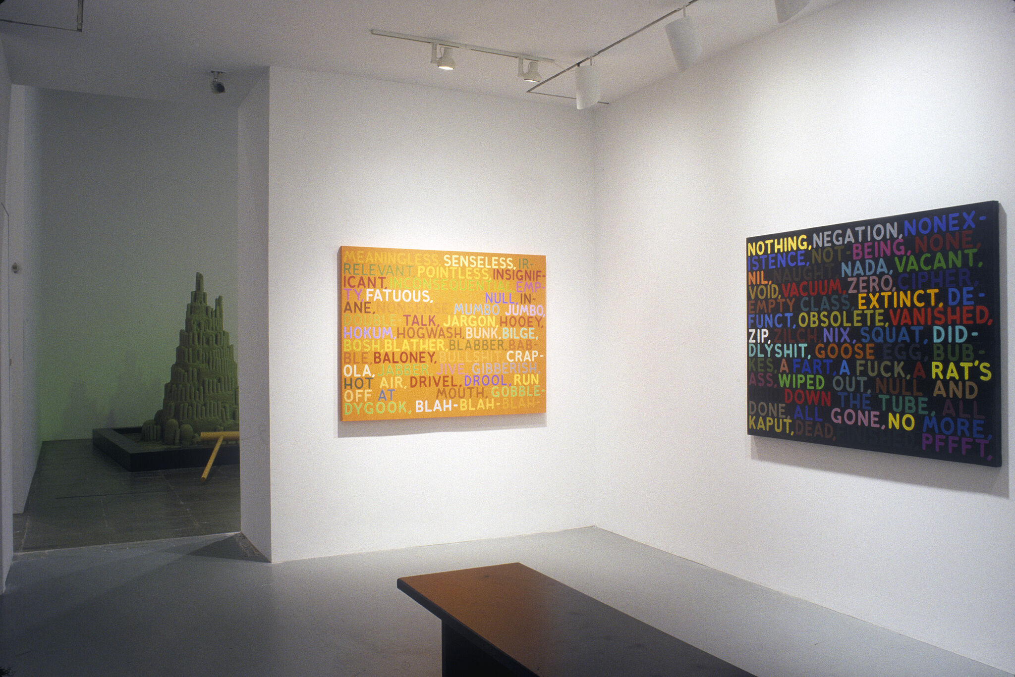An orange painting covered in text, along with a black paintings covered in text.