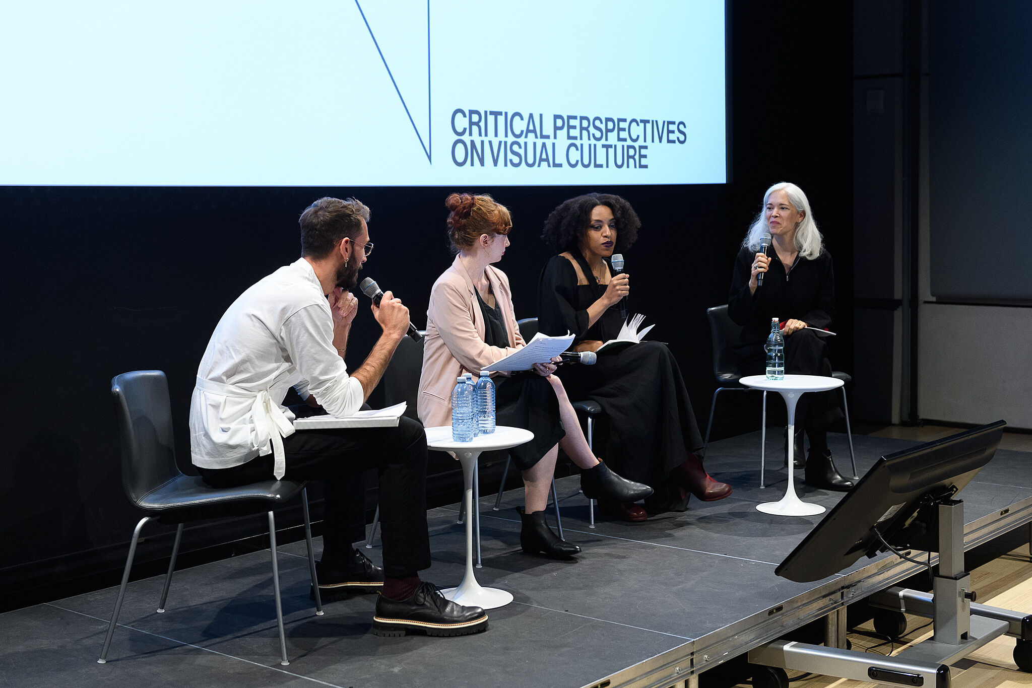 A symposium of people on a stage.