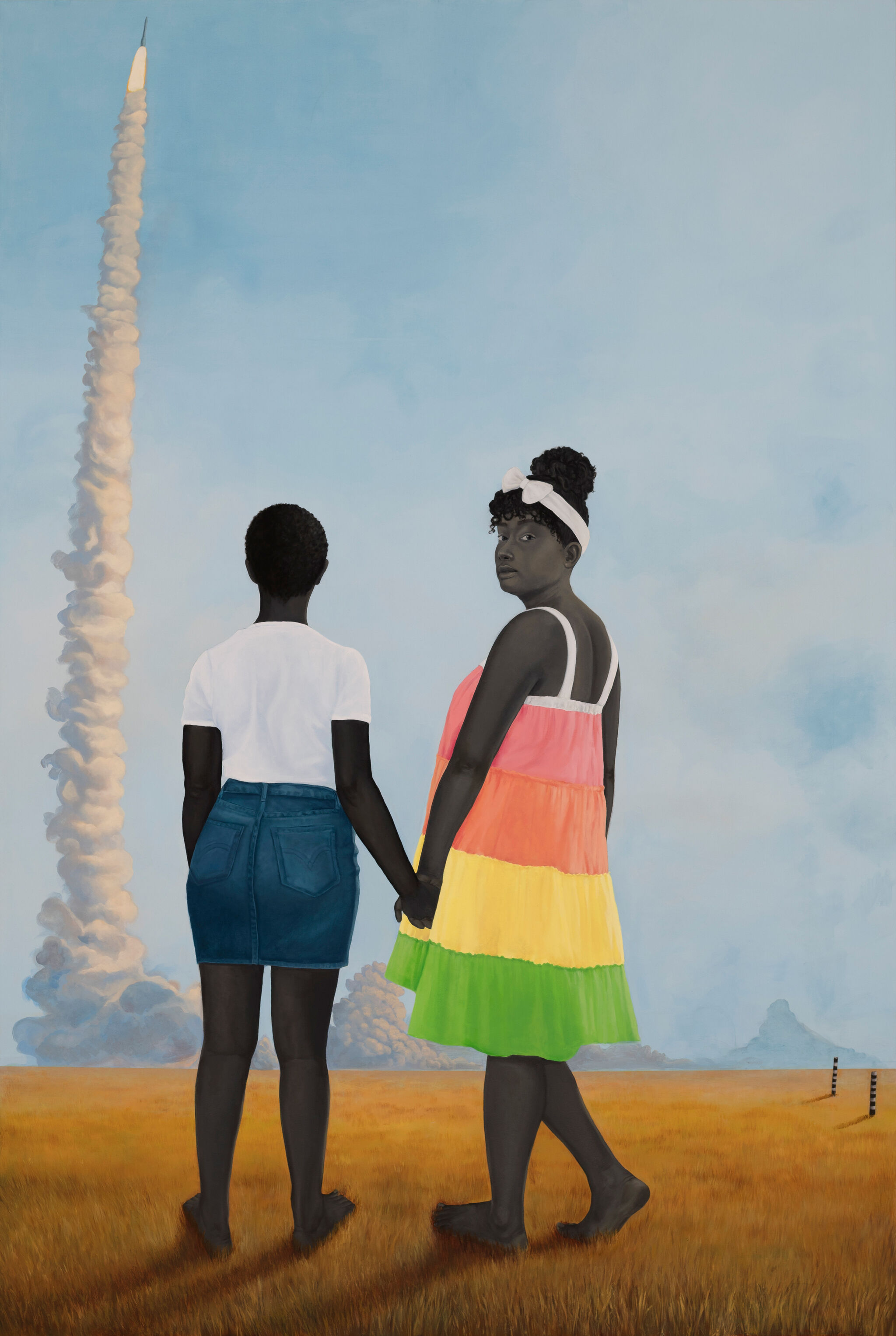 Two figures, one wearing a white t-shirt and denim skirt and other in a colorful sundress, are standing holding hands, one looking at the rocket smoke in the horizon and the other looking back towards the viewer.